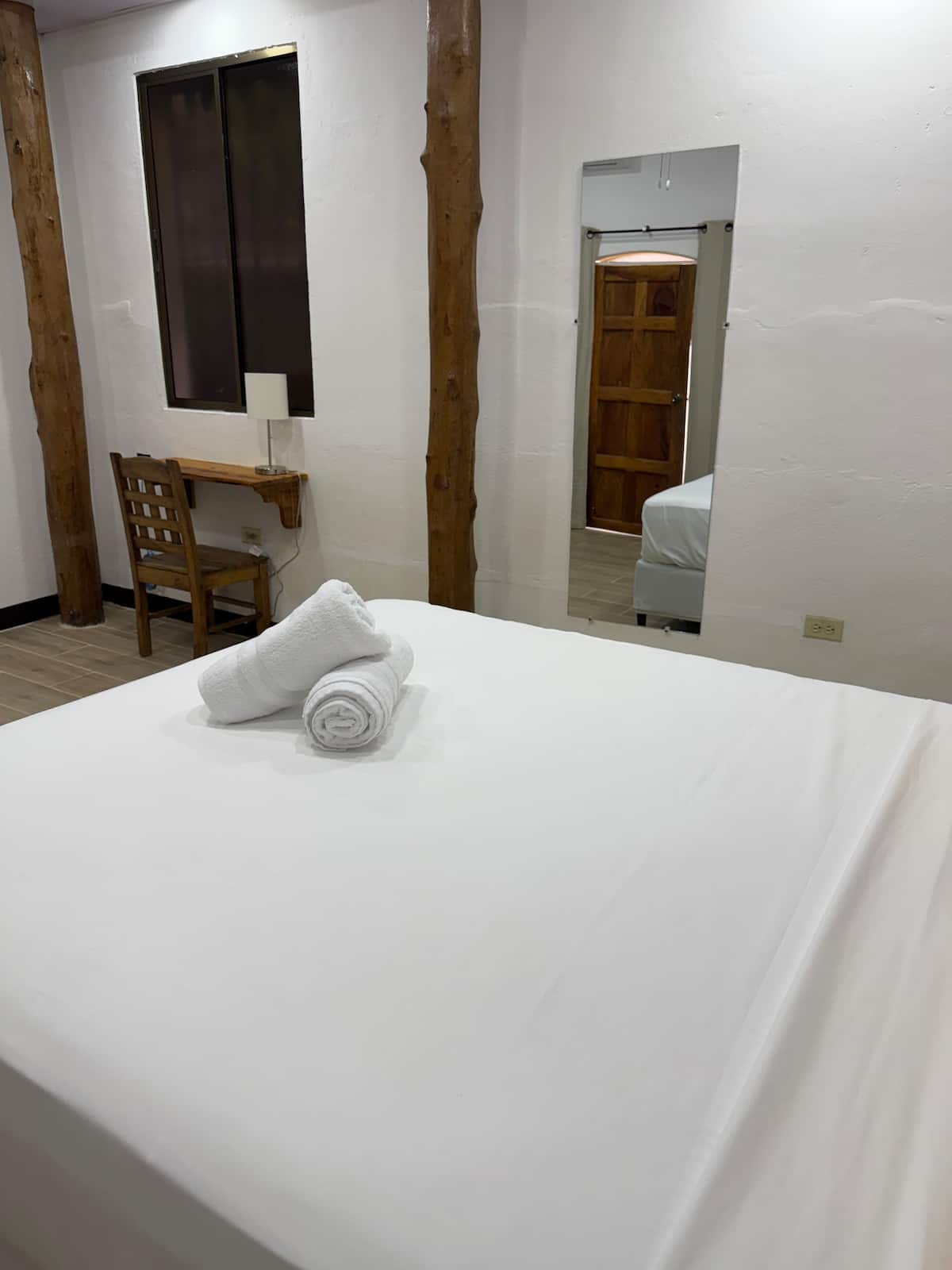 Suite 1 — double bed among rustic wood posts